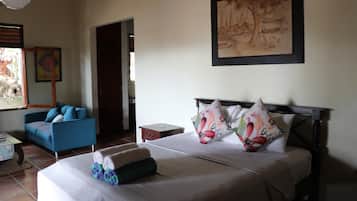 Une chambre à coucher avec un lit, une chaise, une table et un tableau accroché au mur.