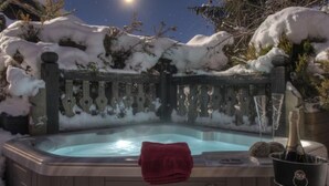 A hot tub with a red towel, surrounded by snow-covered trees and a wooden fence. - CANTATES CHALET with Private Jacuzzi on VRBO (Chamonix Mont-Blanc)