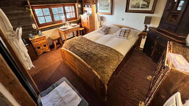 A cozy bedroom with a wooden bed, a desk, a chair, and a window with a view. - Chambre Cabuche with POrivate Jacuzzi (Chamonix Mont-Blanc)