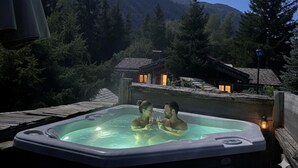 A hot tub with two people, surrounded by a mountainous landscape and a wooden deck. - Chambre Cabuche with POrivate Jacuzzi (Chamonix Mont-Blanc)