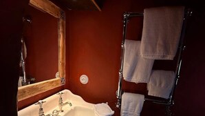 A bathroom with a sink, mirror, and towel rack. - Chambre Cabuche with POrivate Jacuzzi (Chamonix Mont-Blanc)