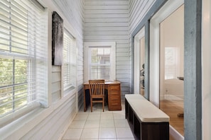 A narrow hallway with a bench, a wooden chair, and a desk with drawers. - Anastasia Oaks 206B High Tide (St. Augustine)