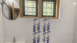 A bathroom with a toilet, sink, and window.