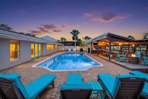 A swimming pool with lounge chairs and a covered patio area. - Canal-Front Beach Home | 5BR/4BA | Private Pool + Boat Dock (Flagler Beach)