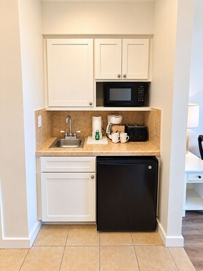 A compact kitchenette with a microwave, coffee maker, toaster, and a dishwasher. - Luau 2–6933 | 9th Floor Gulf Views | King + Sleeper Sofa | Tram Included (Miramar Beach)