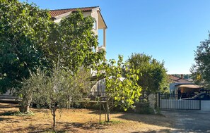 A residential area with a building featuring a tiled roof and a fenced yard. - Lovely apartment in Medulin with WiFi (Medulin)