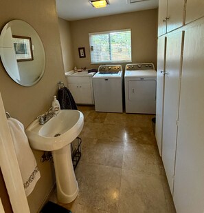 A laundry room with a sink, two washing machines, and a window with blinds. - Awake to Bell Rock, Courhouse Butte & Castle Rock; Walk to trails & more! (Sedona)