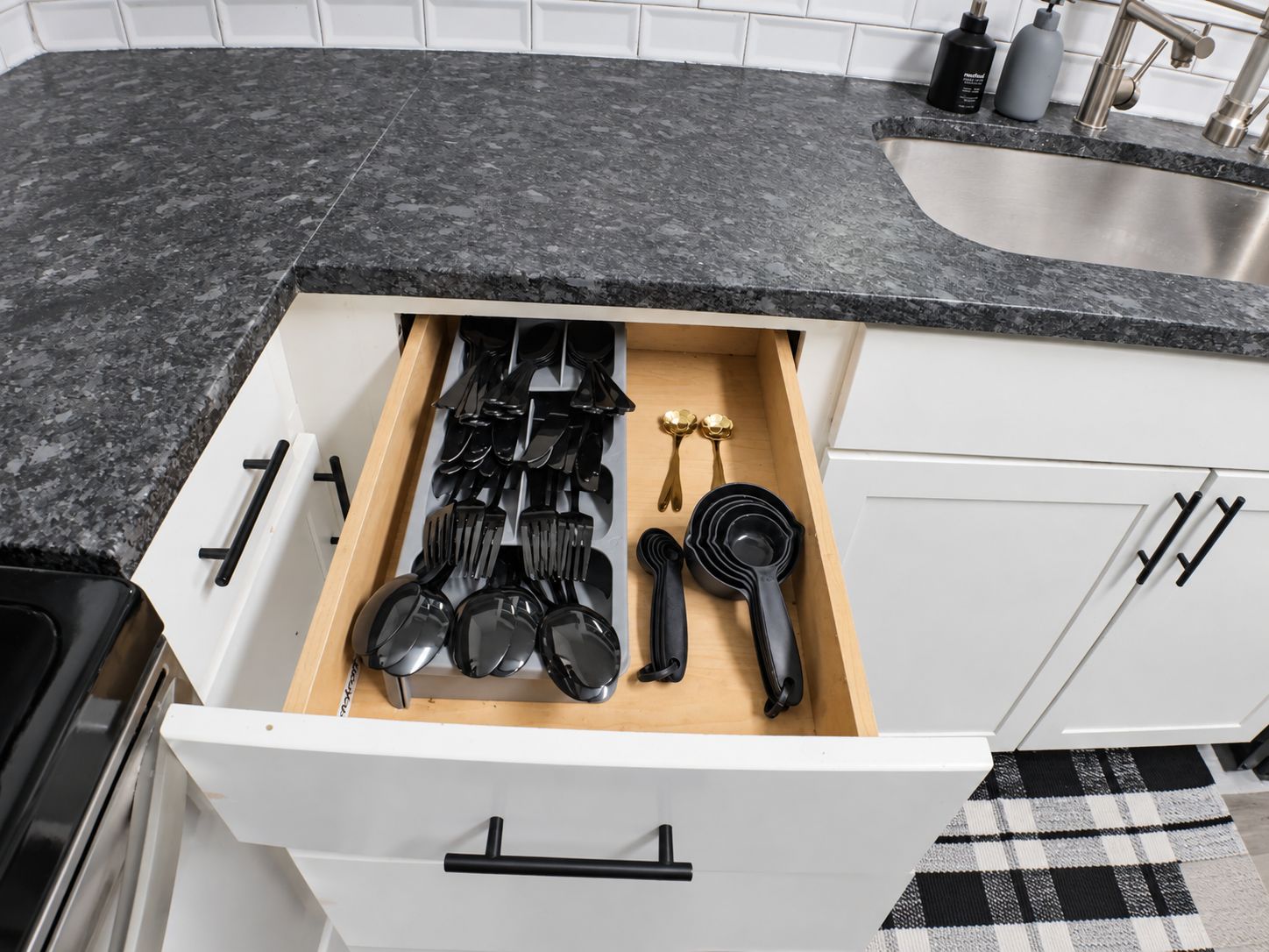 A kitchen drawer with utensils and cookware.