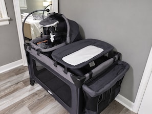 A portable baby stroller with a tray table and a storage basket.