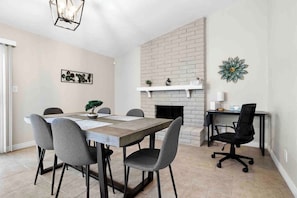 A dining area with a brick fireplace, a white shelf, and a desk with a chair. - Scottsdale Sahuaro Villa 🌵⛳ Private Pool Near Mayo Clinic & McDowell Mtns (Scottsdale)