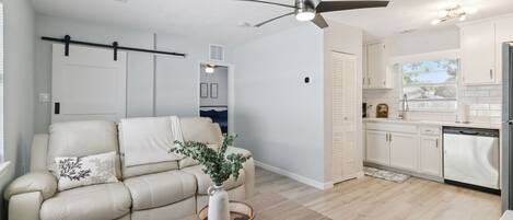 Un salon moderne avec un canapé, une table basse et un ventilateur de plafond.