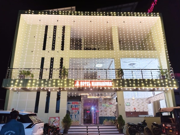 A hotel with a sign reading 'HOTEL MANSAROVAR' and a balcony with string lights. - HOTEL MANSAROVAR (Omkareshwar)