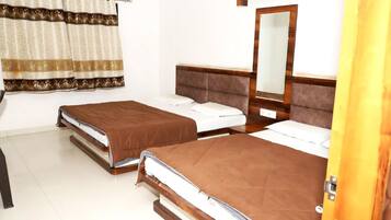 Habitación de hotel con dos camas, un espejo y una cortina.