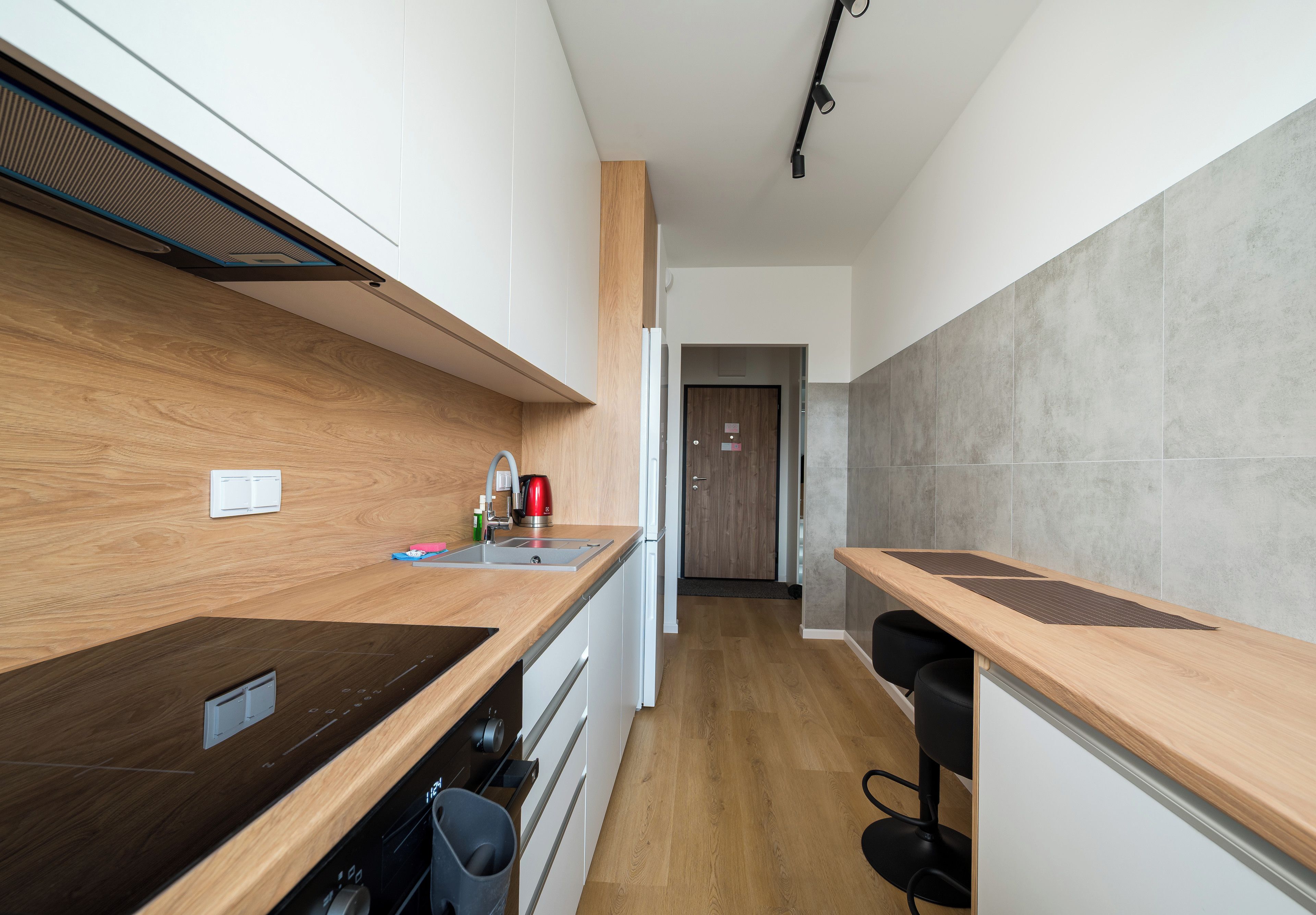 Une cuisine moderne avec des plans de travail en bois, un four encastré et une machine à café.