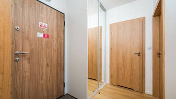 Een hotelkamer met houten deuren, een spiegel en een deurmat.