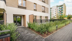 Een modern meerlaags woongebouw met een platte gevel, grote ramen en een hekwerk.