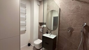 Une salle de bain moderne équipée de toilettes, d’un lavabo et d’une douche.