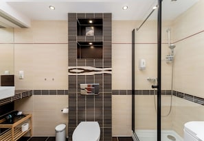 Ein modernes Badezimmer mit Dusche, Toilette und Waschtisch mit Spiegel.