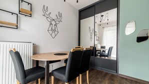 Een moderne vergaderruimte met een ronde tafel, zwarte stoelen en een houten vloer.
