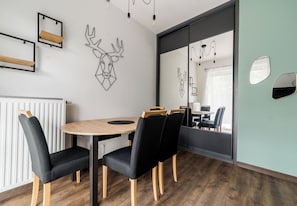 Una sala de reuniones moderna con una mesa redonda, sillas negras y piso de madera.