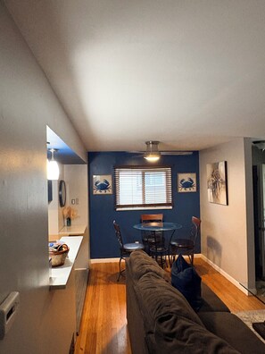 A compact living space with a dining area, a couch, and a small table. - Charming 3-bedroom house with AC in vibrant Detroit (Detroit)