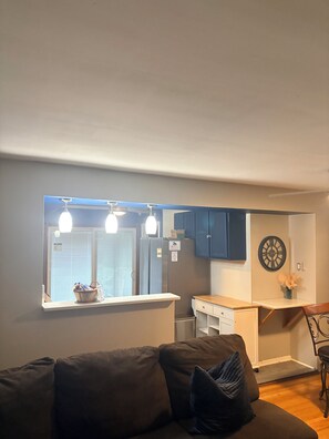 A modern kitchen with a window, a refrigerator, and a clock on the wall. - Charming 3-bedroom house with AC in vibrant Detroit (Detroit)