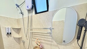 Kylpyhuone, jossa on wc, pesuallas, suihku ja seinälle asennettu televisio.