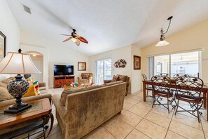 A spacious living room with a television, sofa, and dining area. - Great location with conservation views (Clermont)
