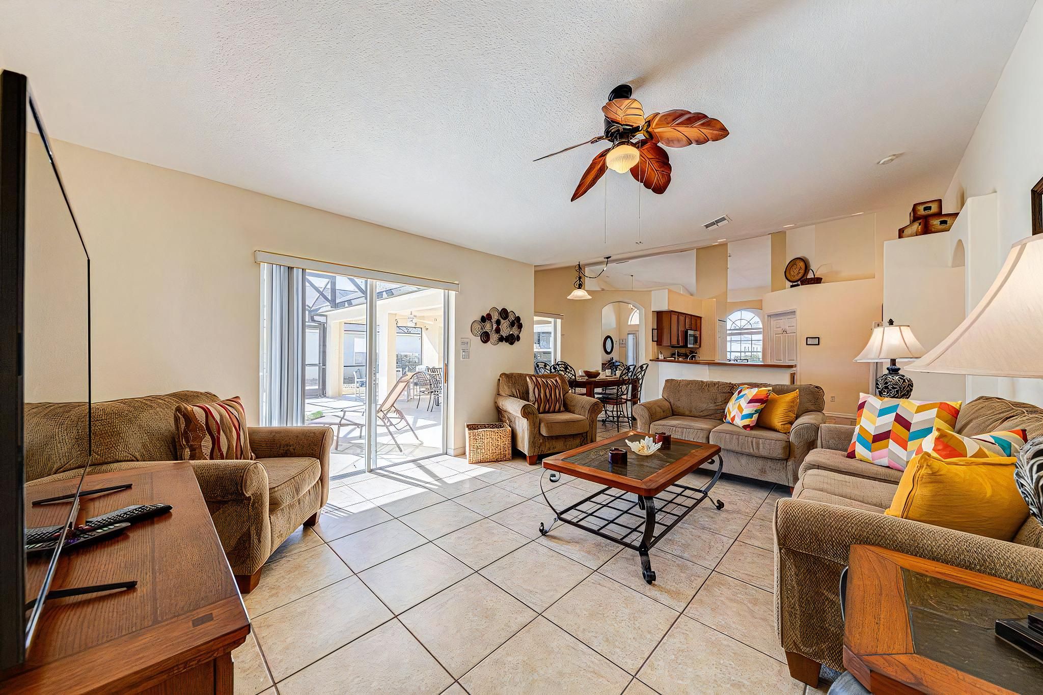 A spacious living room with a ceiling fan, a dining area, and a kitchen.
