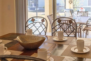 A dining area with a table set for two, featuring woven placemats, white ceramic cups, and a woven bowl centerpiece. - Great location with conservation views (Clermont)