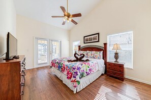 A bedroom with a bed, a ceiling fan, a dresser, a lamp, and a window with blinds. - Great location with conservation views (Clermont)
