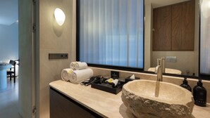 Suite | Badkamer | Een douche, een haardroger, handdoeken, zeep