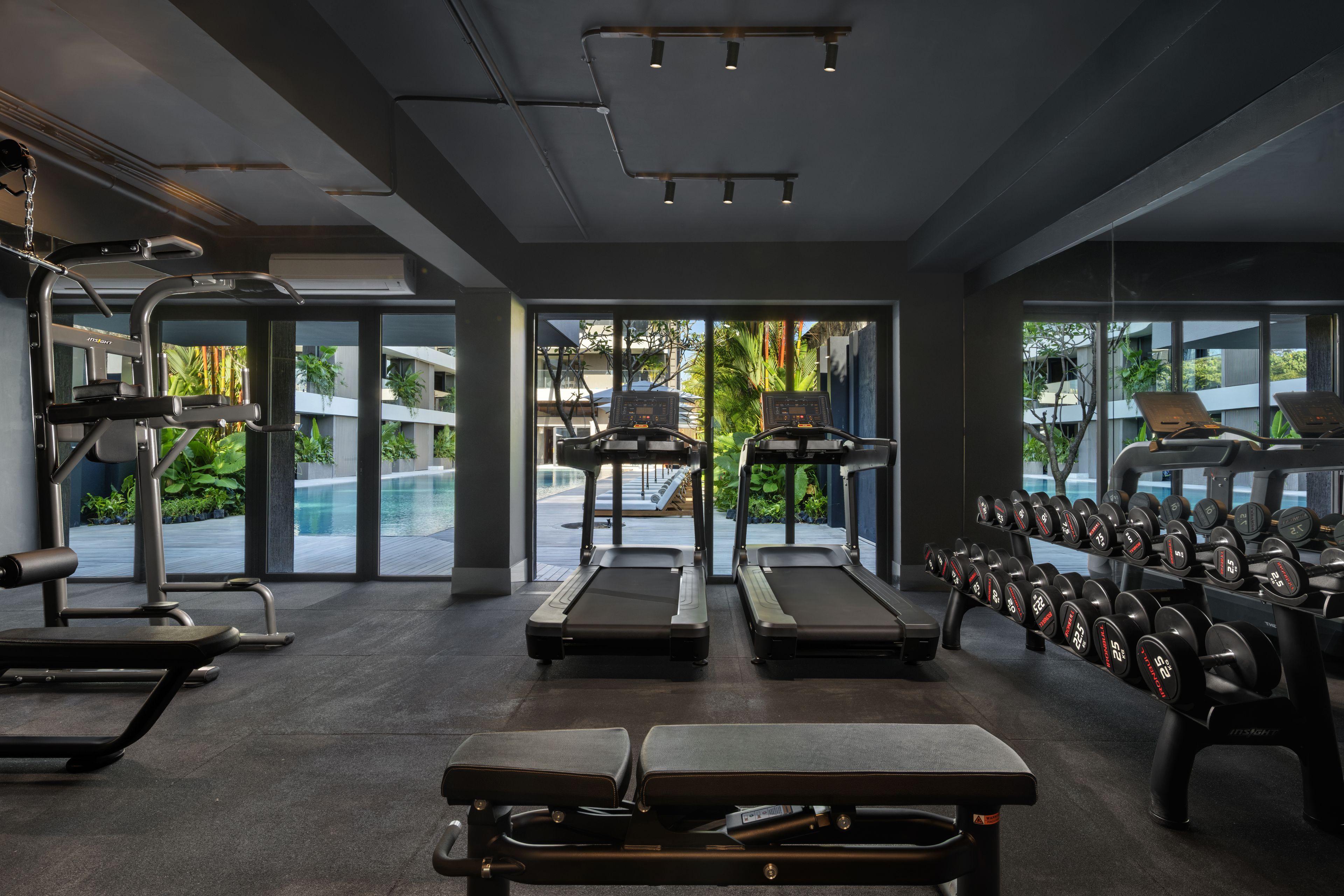 Un gimnasio moderno con cintas de correr, mancuernas y equipo de ejercicio.