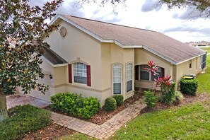 A single-story house with a tiled roof, a garage, and a well-maintained front yard with various shrubs and a small tree. - Quiet cul-de-sac location (Davenport)