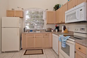 A kitchen with wooden cabinets, a refrigerator, a microwave, a toaster, and a dishwasher. - Quiet cul-de-sac location (Davenport)