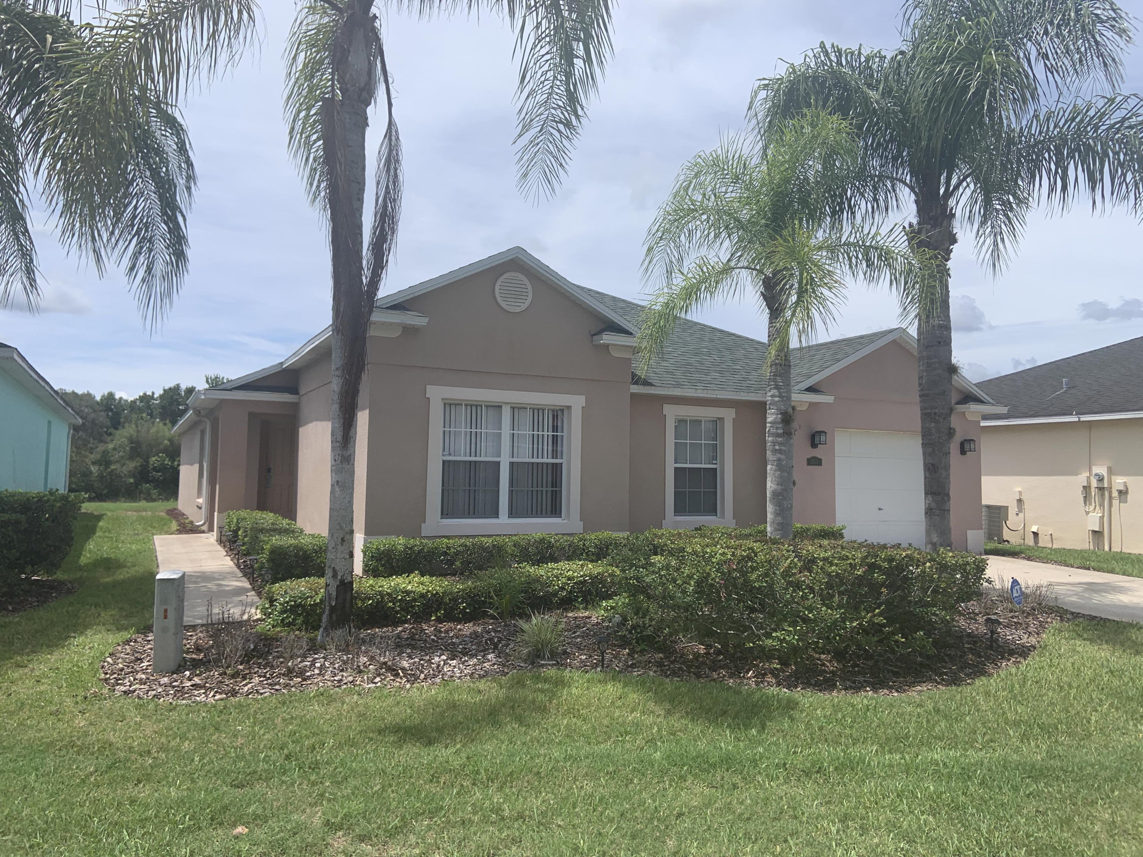 A single-story house with a beige exterior, a front porch, and a garage.