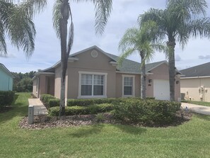 A single-story house with a beige exterior, a front porch, and a garage. - Quiet gated community overlooking conservation (Davenport)