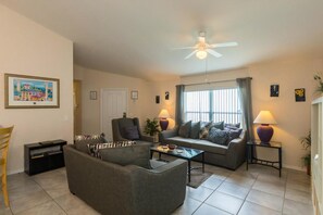 A living room with a sofa, armchair, coffee table, and a ceiling fan. - Quiet gated community overlooking conservation (Davenport)