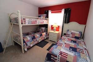 A bedroom with bunk beds, a nightstand, a lamp, and a window with curtains. - Spacious 5 bed on Solana resort (Davenport)
