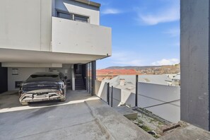A modern two-story building with a car parked in the driveway. - Warwick 1 – Stylish Hobart Retreat (Hobart)