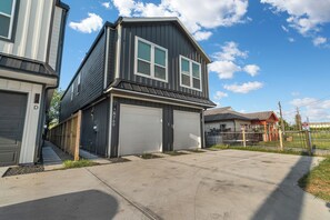 A residential house with a garage, a driveway, and a fenced yard. - Modern 3BR Houston Retreat Stylish & Spacious (Houston)