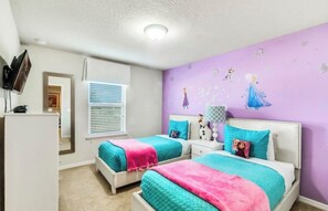 A bedroom with two beds, a dresser, and a wall with a character decal. - Vrbo Property (Four Corners)
