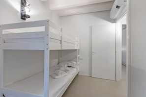 A bunk bed room with a door and a light fixture on the wall. - La Molinella garden suite apartement, Formigine, Italy (Formigine)