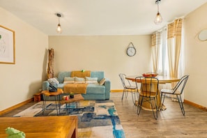 Ein gemütliches Wohnzimmer mit einer Couch, einem Couchtisch und einem Essbereich mit Stühlen und einem Tisch.