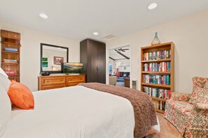 A bedroom with a large bed, a wooden dresser, a bookshelf, and a television. - La Shika Chalet | Dogs Welcome | Sleeps 12 (Beech Mountain)