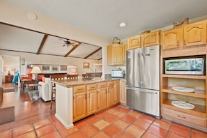 A kitchen with wooden cabinets, a stainless steel refrigerator, and a built-in microwave. - La Shika Chalet | Dogs Welcome | Sleeps 12 (Beech Mountain)