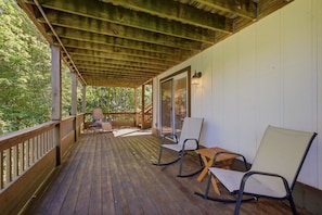 A wooden deck with a railing, two chairs, and a table. - La Shika Chalet | Dogs Welcome | Sleeps 12 (Beech Mountain)