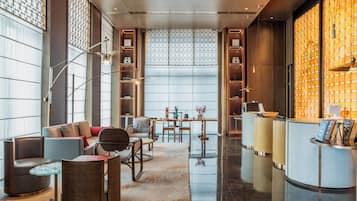 A modern hotel lobby with a reception desk, seating area, and decorative elements.