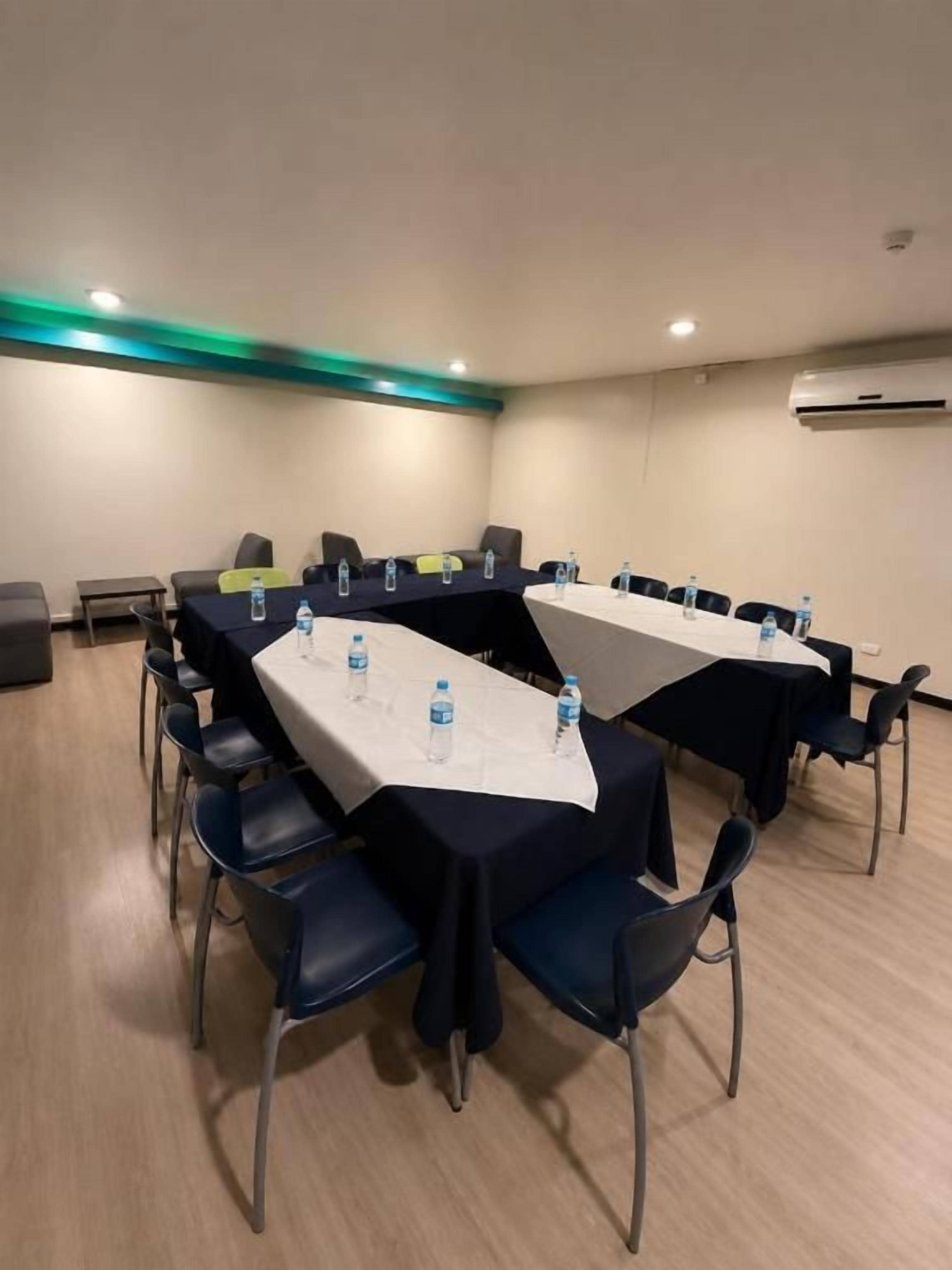 A conference room with a long table, chairs, and water bottles.