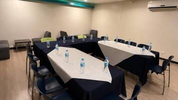A conference room with a long table, chairs, and water bottles.
